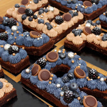 Indlæs billede til gallerivisning Snirkleriet tilbyde tal- og bogstavkager i flere størrelser. Small lettercakes består af browniebunde med topping og bærfyld.
